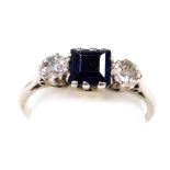 A platinum sapphire and diamond three stone ring, with a square cut sapphire flanked by a pair of br