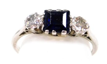 A platinum sapphire and diamond three stone ring, with a square cut sapphire flanked by a pair of br