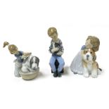 A Lladro Porcelain figure of a girl kneeling washing her dog in a tub, and two Nao figures, one of a