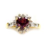 A heart shaped cluster ring, set with a tourmaline stone, surrounded by fourteen tiny diamonds, thre
