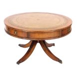 A reproduction mahogany drum library table, with a tooled pale brown leather top, with four frieze d