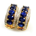 A pair of sapphire and diamond set hoop earrings, clip and post backs, each with five oval faceted s