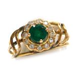 An emerald and diamond set dress ring, openwork design, a central round 4.9mm diameter emerald (heav