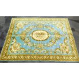 An Aubusson type blue ground rug, decorated in gold with a central floral medallion, within a border