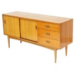 An Austinsuite mid century teak sideboard, with two sliding doors, enclosing a single shelf, flanked