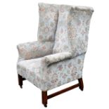 An Edwardian mahogany wing armchair, upholstered in pale blue, red and gold floral fabric, 83cm wide