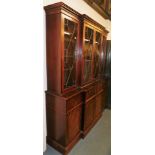 A 20thC mahogany breakfront display cabinet, the top with a moulded dental cornice, above four astra