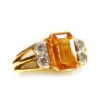 A yellow stone and diamond set dress ring, the central stone (possibly topaz) of 8.4mm x 5.8mm set w