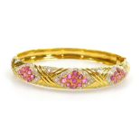 A ruby and diamond set hinged bangle, three ruby set lozenge shaped motifs of nine stones of 2mm ea