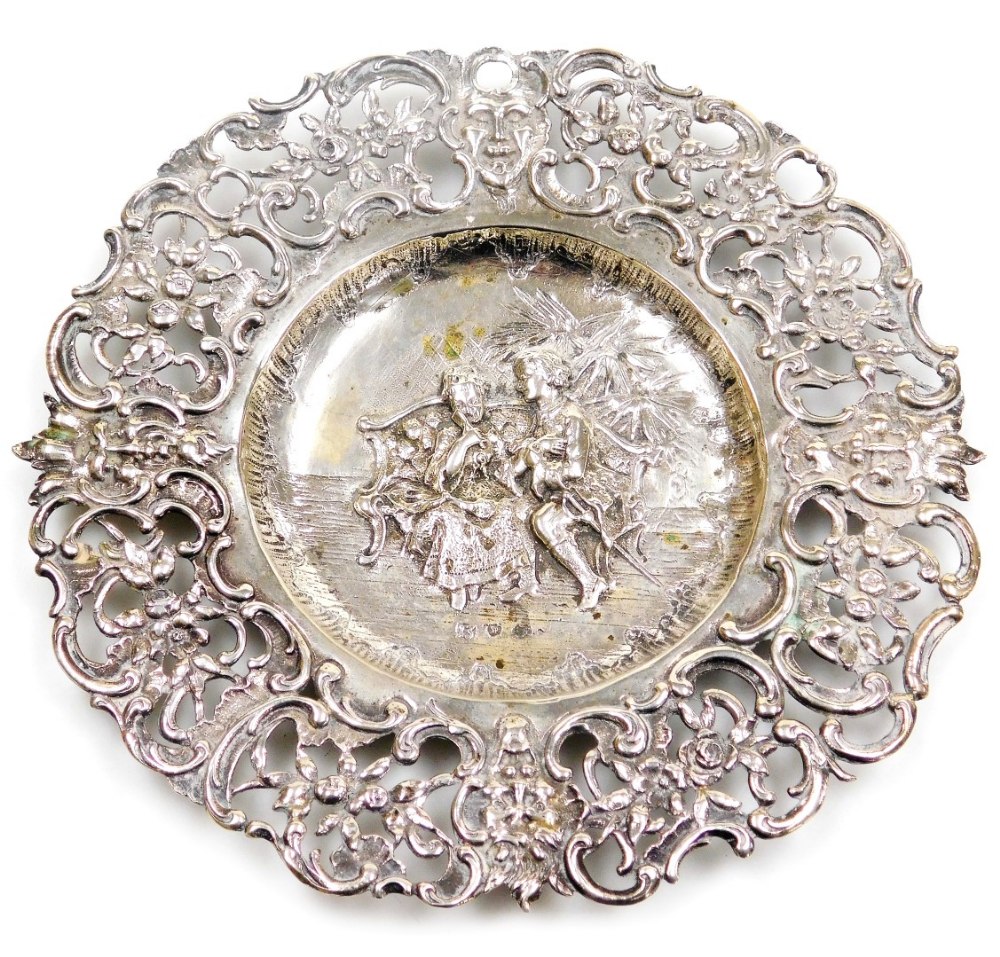 A Continental white metal dish, with a pierced floral and scroll decorated border, the centre emboss