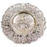 A Continental white metal dish, with a pierced floral and scroll decorated border, the centre emboss