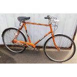 A Raleigh Esquire bicycle, in metallic orange trim.