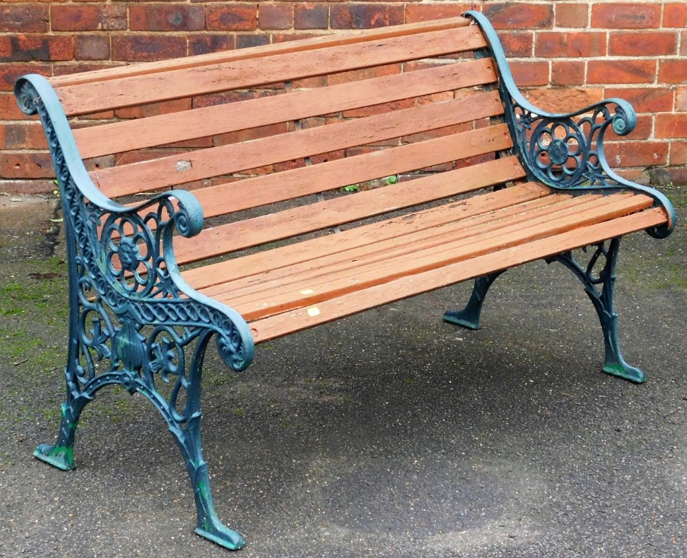 A garden bench, with slatted back and seat with cast metal ends, 127cm wide.