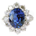 An 18ct white gold sapphire and diamond cluster ring, with oval cut blue sapphire, totaling 7.05ct,