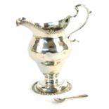 A George III silver cream jug, of baluster form with gadrooned rims, s scroll handle, Charles Cheste