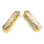 Two George V silver backed dressing table brushes, each with engine turned striped decoration, and c