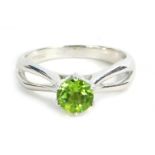 A 9ct white gold dress ring, set with round brilliant cut peridot in claw setting with twist design