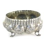 An Indian white metal sugar bowl, fluted and repousse decorated with palm trees and flowers, raised
