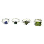 Four dress rings, comprising a CZ M&S green stone ring, a silver blue CZ set dress ring, a costume j
