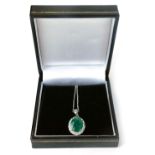 An 18ct gold emerald and diamond cluster pendant, with oval emerald, totaling approx 3.55ct, in a fo