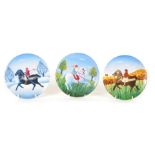 Three Poole pottery plates, each depicting figures on horseback, 15.5cm diameter.