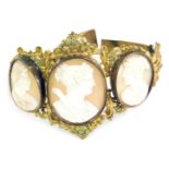 A late 19thC/early 20thC shell cameo bracelet, formed with three oval cameos depicting maidens in fl