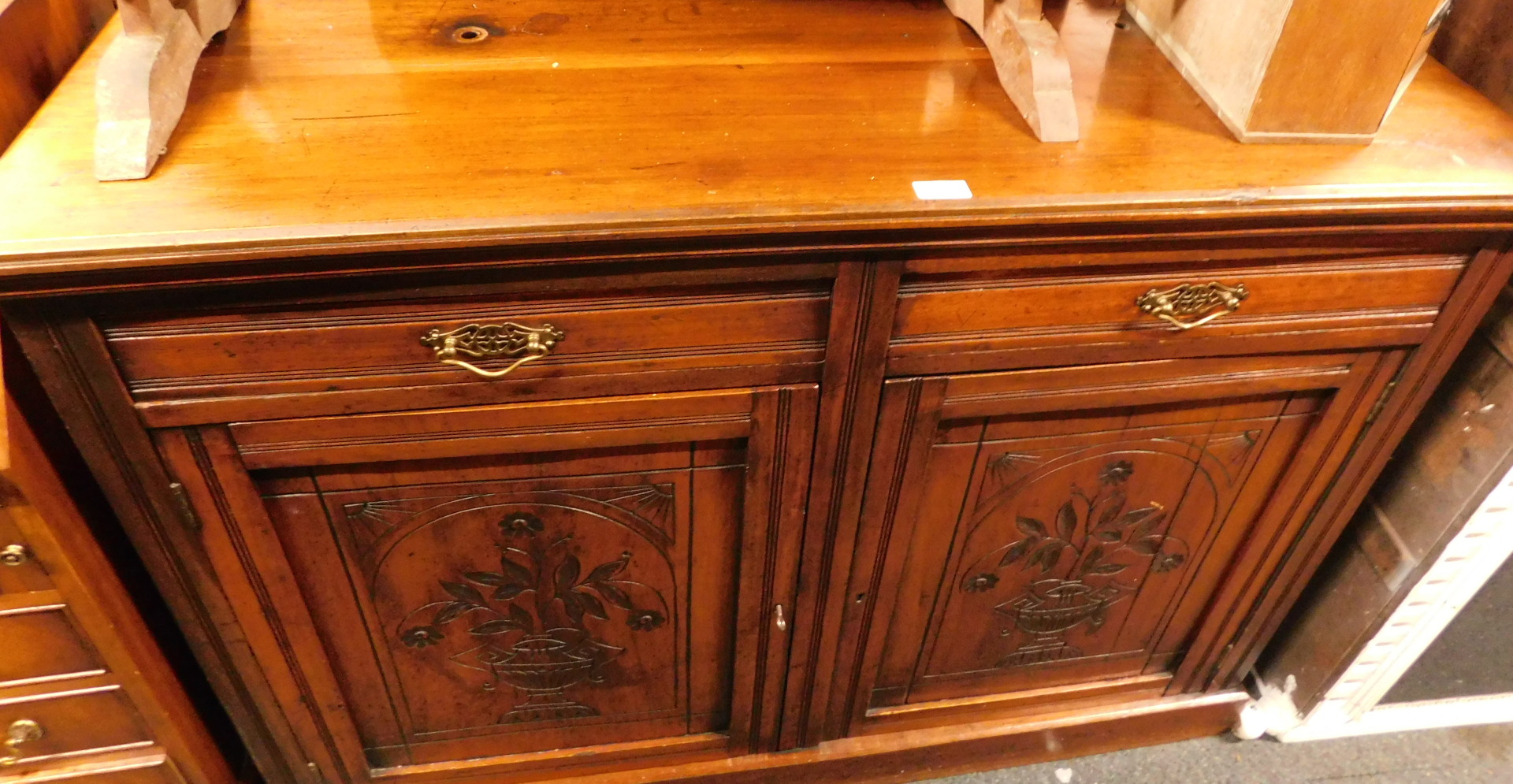 A mahogany sideboard, with arrangement of two drawers, and two carved cupboard doors.