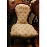 A Victorian mahogany spoon back nursing chair, on cream floral upholstery, with pink ribbon surround