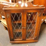 An oak hanging corner cabinet, with two astragal glazed and lead lined doors.