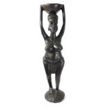 An African carved tribal figure, of a semi clad lady holding bowl to her head on domed base, 66cm hi