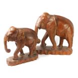 A graduated pair of carved wooden tribal elephant figures, 39cm high, etc. (2)