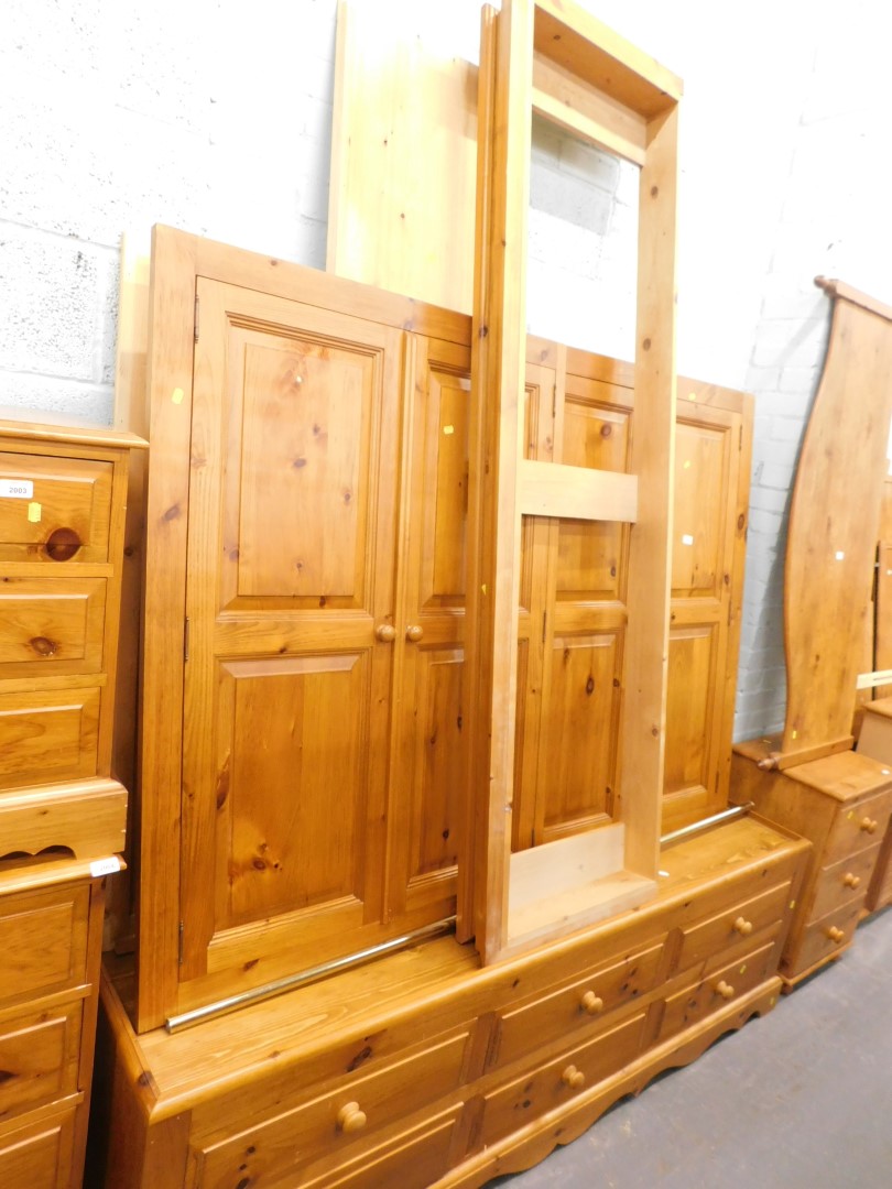 A pine triple wardrobe, with four panelled doors and six drawers to the base. (unassembled)