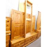 A pine triple wardrobe, with four panelled doors and six drawers to the base. (unassembled)