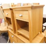 A pair of light oak bedside cabinets each with a frieze drawer and a recess and a label for a Bentle