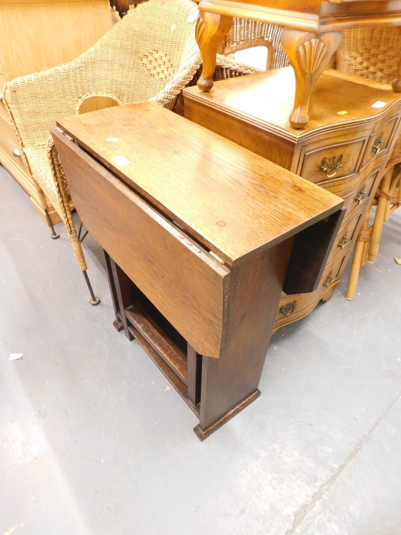 A 1920s oak drop leaf table with rectangular top and cantied corners on end supports.