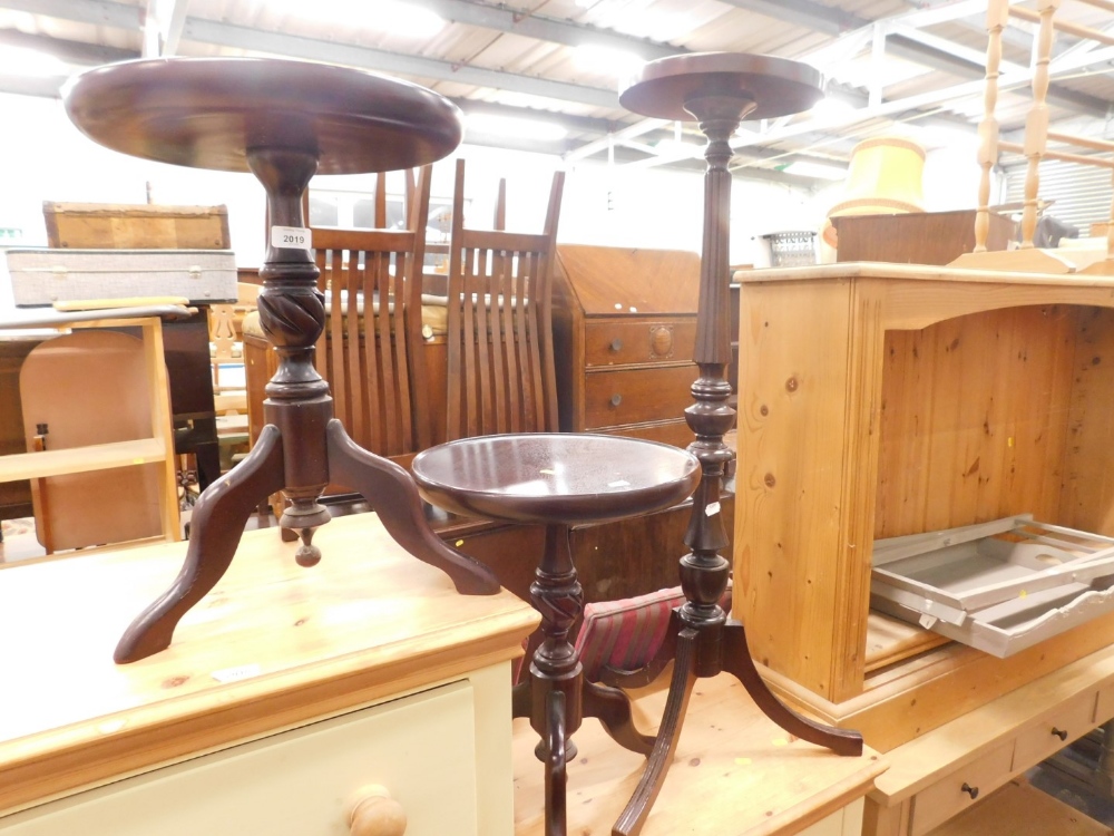 A pair of mahogany wine tables, each on turned column tripod bases and a similar plant stand. (3)