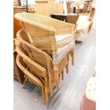A set of four basket woven Lloyd Loom style tub chairs each with turned legs.