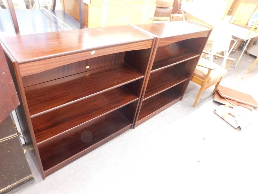 A pair of mahogany effect open bookcases, each on a plinth base.