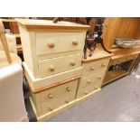 A suite of three pine chest of drawers each with painted bases comprising of two beside chests and a