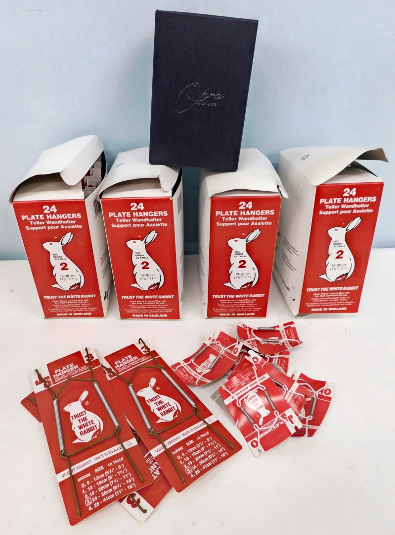 A large quantity of white rabbit plate hangers, partially boxed, some loose, and a quantity of vacan