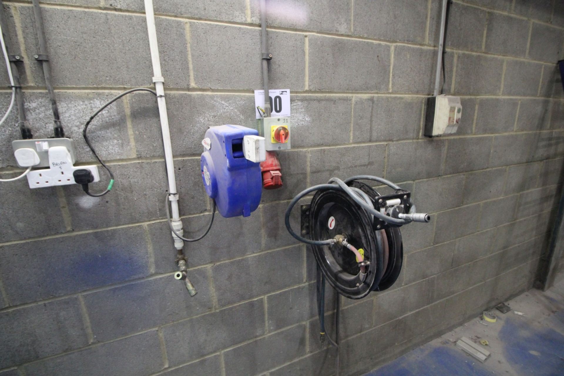 WALL MOUNTED, BLACK SPOOL AND CONTENTS OF AIR LINE, AND WALL MOUNTED, 240V, CABLE REEL. THE