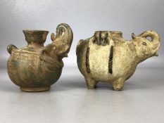 Two clay pouring jugs with applied elephant head spouts, the largest on four feet and approx 11.