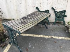 Wooden garden table with green painted metal ends, together with two pairs of green metal bench