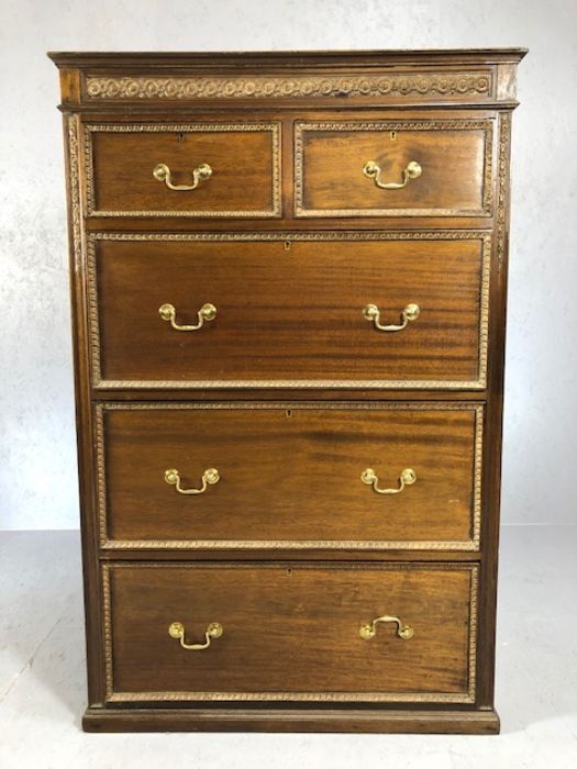 Tall chest of three large and two small drawers with carved detailing and brass handles. approx 87cm