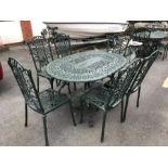 Green painted oval garden table and six chairs, table approx 138cm in length