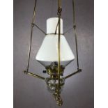 Hanging oil lamp with a combination of clear and white opalescent glass, suspended in a brass