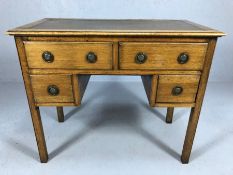 Small knee hole oak four drawer leather topped writing desk with circular handles, approx 92cm x