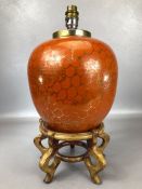 Chinese ginger jar converted to a lamp with orange ground and gold floral decoration, on wooden