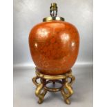 Chinese ginger jar converted to a lamp with orange ground and gold floral decoration, on wooden