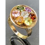 Unmarked Gold ring set with with seven Gemstones in a daisy cluster on a starburst Gold setting.